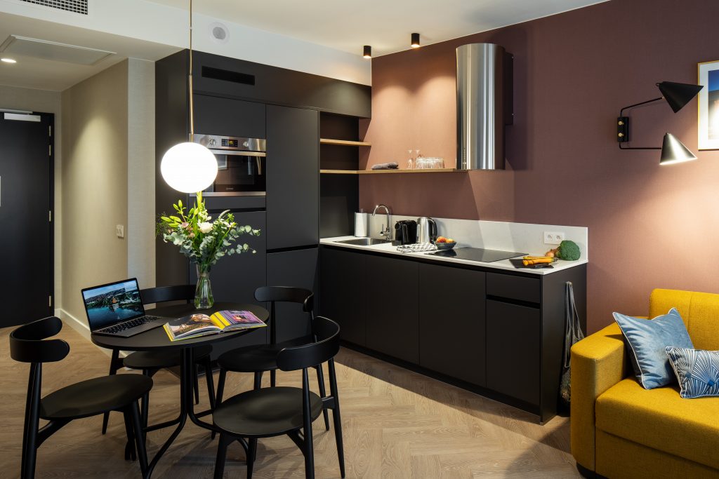 Keukengedeelte met ronde eettafel en stoelen in Aparthotel Yays Antwerpen.